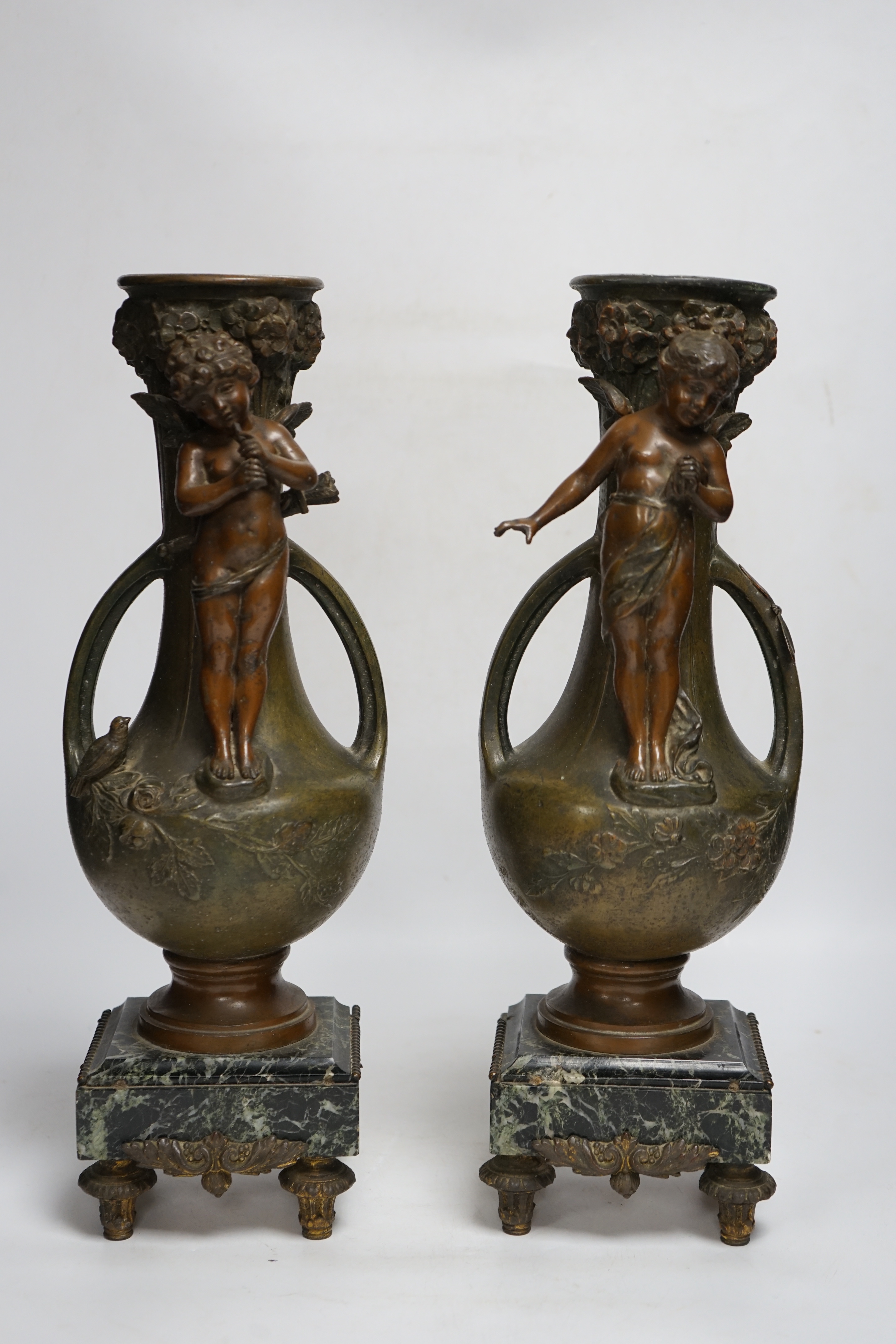 After Hippolyte François-Moreau (1832-1927), a pair of bronzed spelter cherubic vases on marble bases, 42cm